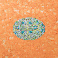 oval with fancy pattern on orange tissue paper with texture