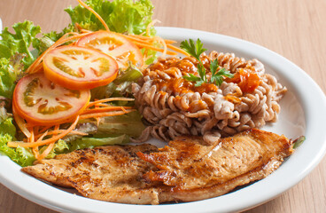 delicioso prato saudável com carne de frango e salada de alface e tomate e macarrão integral de fuso