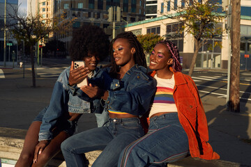 Portrait of young friend group together in the city on the phone taking selfies 
