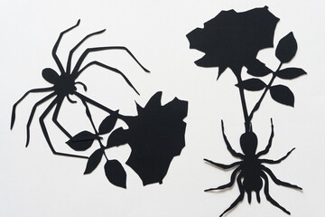 black paper silhouettes of spiders and roses
