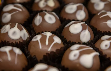 Fotobehang Closeup of delicious brown and white chocolate cupcakes in a sweets shop © Adrian De La Paz/Wirestock Creators