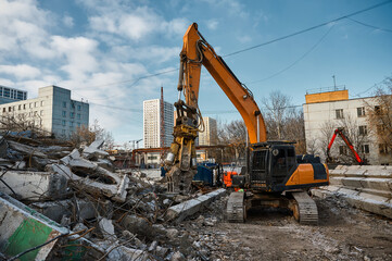 Fototapeta premium Excavator with hydraulic scissors cuts concrete beams