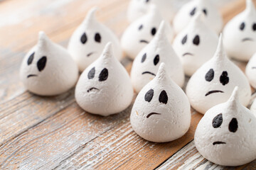 Halloween recipes ghost shape marshmallow candies with chocolate faces, close up studio shot