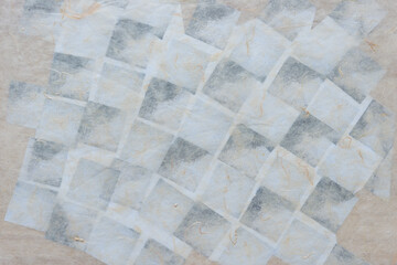 background with tissue paper and faint checkered pattern design beneath