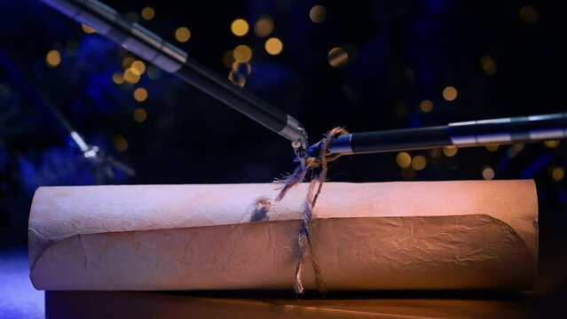 Small forceps of robotic arms tie a rope on the scroll. High precise equipment performs delicate work making a knot. Close up. Dark backdrop with blurred lights.