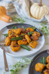 Healthy home made Pumpkin gnocchi with cheese and fresh herbs on a table