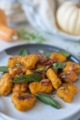 Healthy home made Pumpkin gnocchi with cheese and fresh herbs on a table
