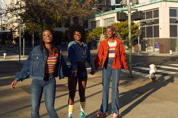 Portrait of young friend group together in the city smiling on rollerskates