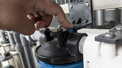 The man pressing the pressure relaease button for replace the  case water filter.