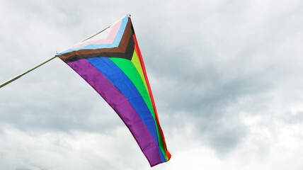 LGBT rainbow flag waving with blue sky in background to enhance LGBTQ+ community around the world