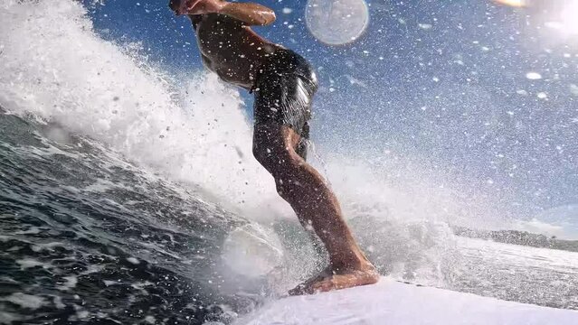 Point of view of extreme surfer surfing blue ocean wave 