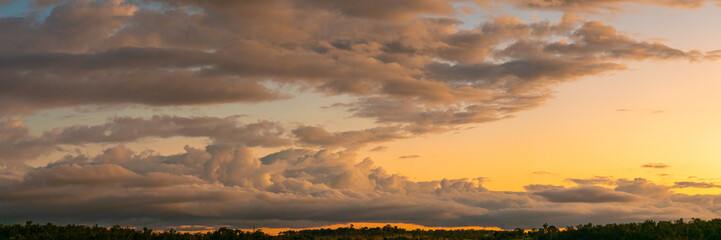 Fototapeta na wymiar Panoramic sunset view in outback Queensland, Australia during autumn with dramatic clouds. 