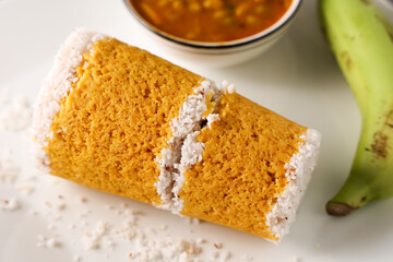 Popular South Indian breakfast puttu pittu made of corn flour and coconut in a bamboo mould, with banana, Kerala, India. Bamboo puttu prepared in the bamboo utensil.