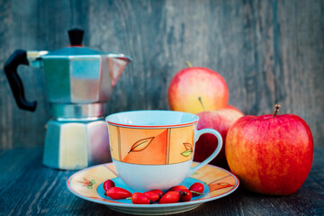 A cup of tea, rose hips, apples and a kettle. Vitamins, disease prevention
