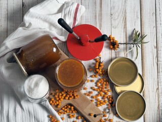 Homemade jam preparations from healthy sea buckthorn for future use.Glass jars with jam on a wooden background.Top view.