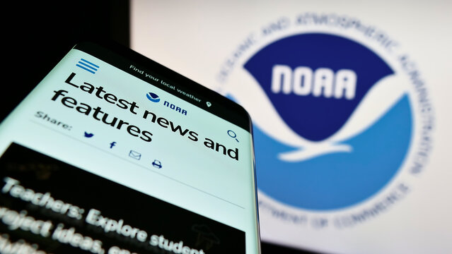Stuttgart, Germany - 10-09-2022: Mobile phone with website of National Oceanic and Atmospheric Administration (NOAA) on screen in front of logo. Focus on top-left of phone display.