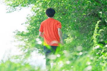 外でジョギングする男性の後ろ姿