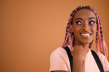 Studio portrait of young  beautiful non-conforming with braids smiling
