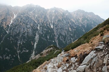 Beautiful views on tourist trail from Valley of Five Polish Ponds through Swistowka Roztocka to Sea Eye (Morskie Oko) pond. Silhouette of hiking people on trail. Tatra, Carpathians, Poland