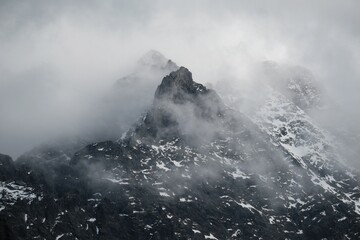 Dramatic scenery of rocky mountain peaks in clouds. Rysy and Niznie Rysy in the High Tatras....