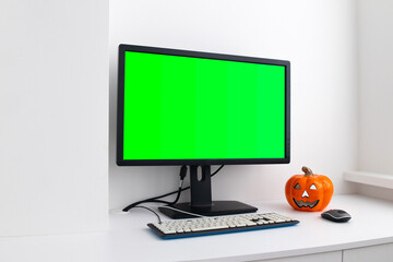 Chroma key mock-up on computer in the white home interior. Pumpkin on the table