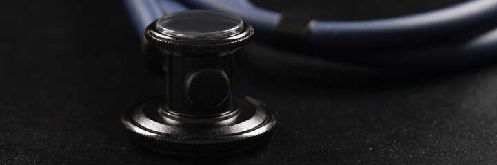 Fototapeta na wymiar Medical stethoscope instrument on black surface, tool for patient diagnostic