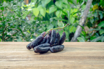 black seedless witch finger grape on wooden floor
