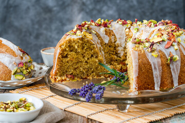 Fragrant Persian love cake decorated with with vanilla icing, crushed pistachio nuts and dried rose...