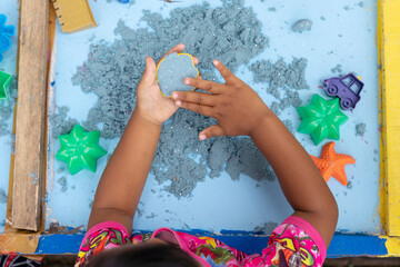 Close up shot of kids playing sands to stimulate their creativity and motoric system