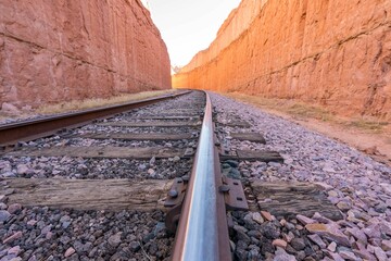 Empty old railway train track passing through a canyon