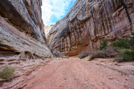 Dirt Road Passing Through Red And Black Rock Formations At A National Park In Utah