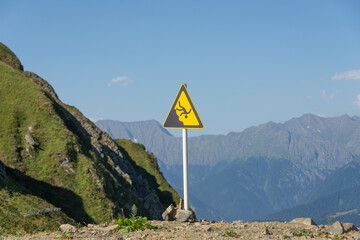 Sign man falling from a height, danger of falling from a cliff, mountain collapses, warning of an abyss.