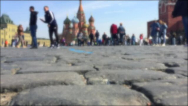 Blurred video of tourists walking on Red Square. Close-up Red Square pavings. Moscow landmarks: Saint Basil's Cathedral and Kremlin. Crowd of people on Red Square.