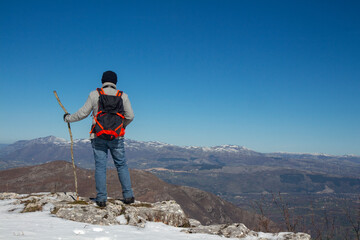 Hiker on the summit of a mountain with snow on the Alburni mountains (SA)