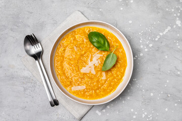 Risotto with pumpkin and pumpkin seeds, parmesan cheese and basil. vegetarian vegan food. risotto alla milanese with saffron. italian cuisine seasonal fall menu. gray background top view 