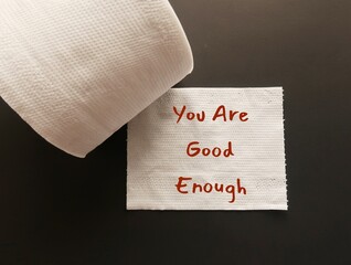 Handwritten text on toilet paper YOU ARE GOOD ENOUGH, positive mantra to overcome self-doubt and...