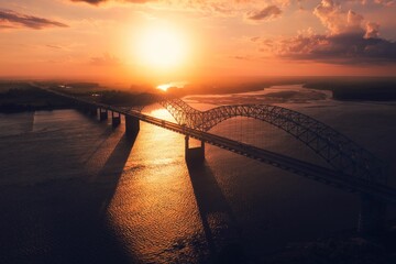 Bird's eye view of Memphis Bridge connecting Tennessee and Arkansas at sunset over Mississippi River