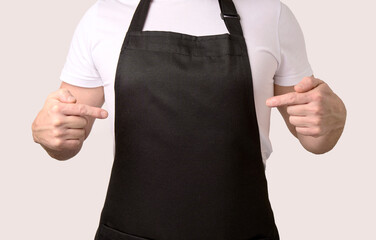 Chef cook pointing on black apron