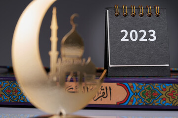 close up of  2023 desk calendar and metal crescent and mosque ramadan decoration item