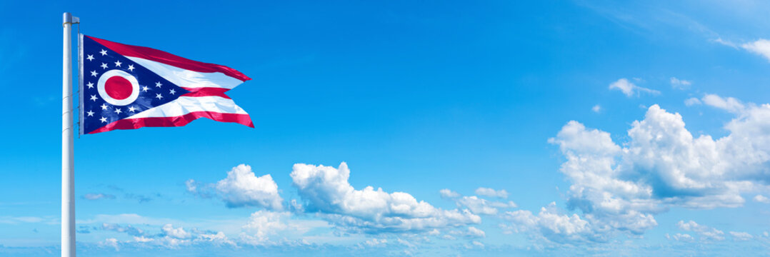 Ohio, USA - flag waving on a blue sky in beautiful clouds - Horizontal banner