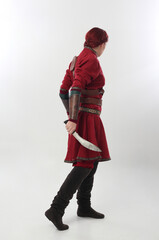 full length portrait of beautiful woman wearing a red medieval fantasy warrior costume with leather...