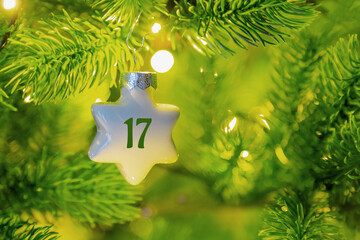 ein Weihnachtsstern mit einer Zahl (17) am Weihnachtsbaum