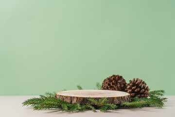 Wooden podium with branches of green spruce and cone on green background. Concept scene stage...