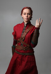  portrait of beautiful woman wearing a red medieval fantasy warrior costume with leather armour. ...