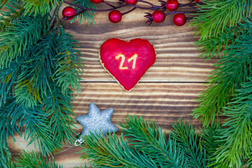 Fototapeta na wymiar leckeres Plätzchen mit einer Zahl (21) auf weihnachtlichen Hintergrund aus Holz