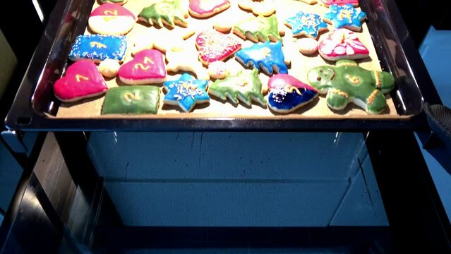 frisch gebackene Pl&auml;tzchen werden aus dem Backofen geholt	