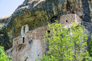 Fototapeta na wymiar The panorama of the Hermitage of San Bartolomeo in Legio built with stones and carved into the rock