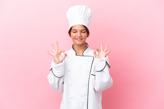 Little caucasian chef girl isolated on pink background in zen pose