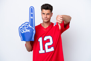Young caucasian sports fan man isolated on white background showing thumb down with negative...