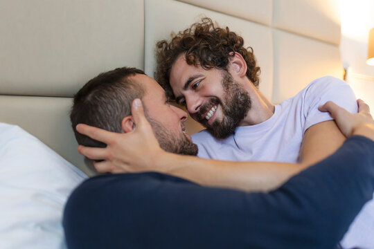 Happy gay couple having tender moments in bedroom - Homosexual love relationship and gender equality concept